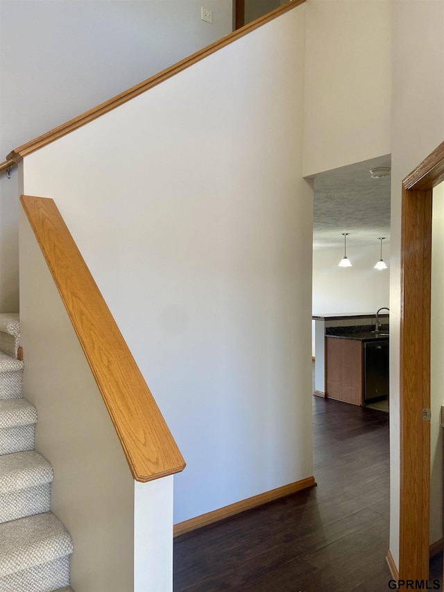 stairs featuring wood-type flooring and sink