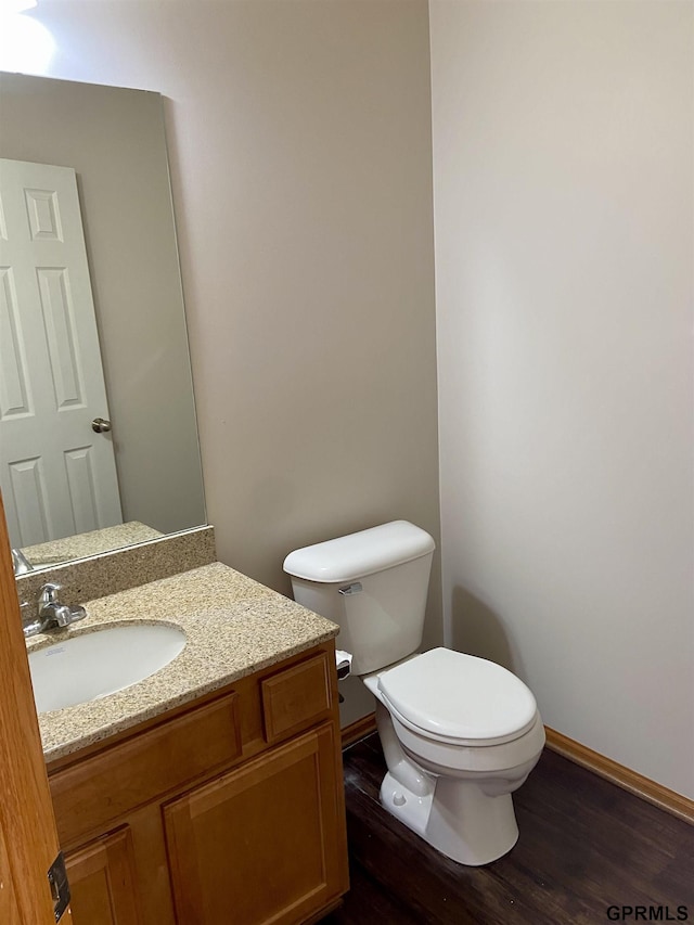 bathroom featuring toilet, hardwood / wood-style floors, and vanity