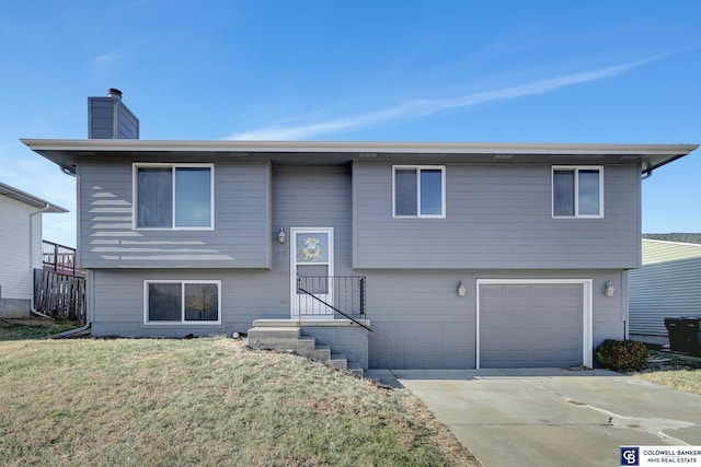 bi-level home featuring a front lawn and a garage