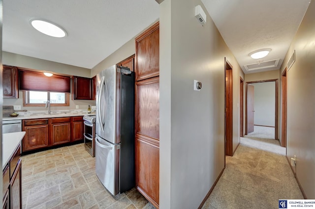 kitchen featuring appliances with stainless steel finishes, light colored carpet, and sink