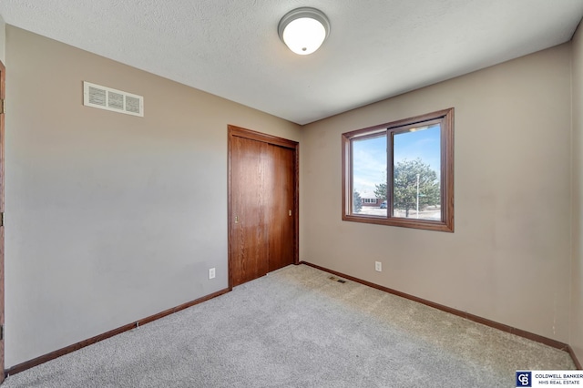 unfurnished bedroom featuring light carpet and a closet