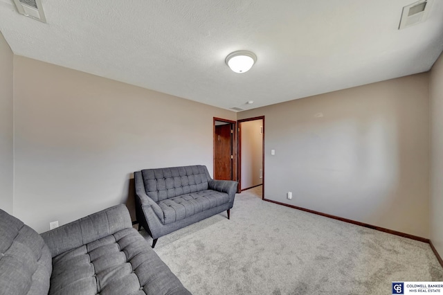 sitting room featuring a textured ceiling and light carpet