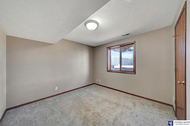 carpeted spare room with a textured ceiling