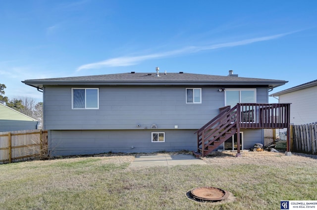 back of house featuring a lawn and a wooden deck