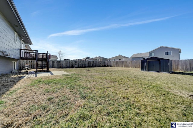 view of yard with a deck and a storage unit