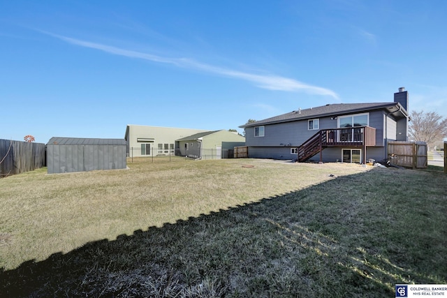 rear view of house featuring a lawn, a shed, and a deck