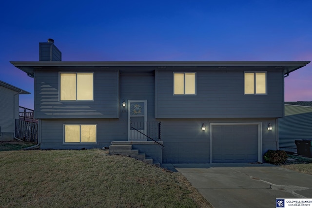 raised ranch with a garage and a yard