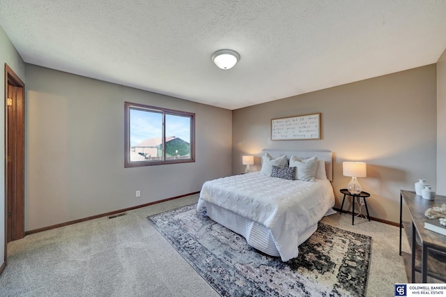 carpeted bedroom featuring a textured ceiling