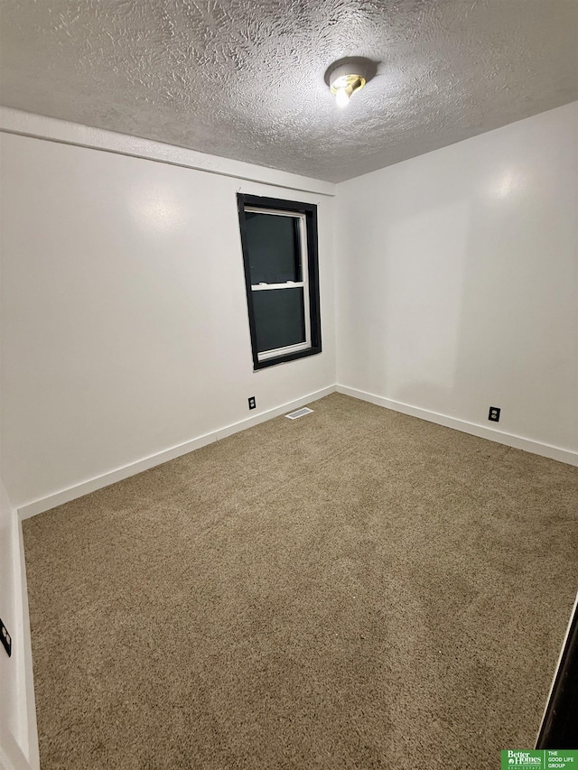 unfurnished room featuring a textured ceiling and carpet flooring