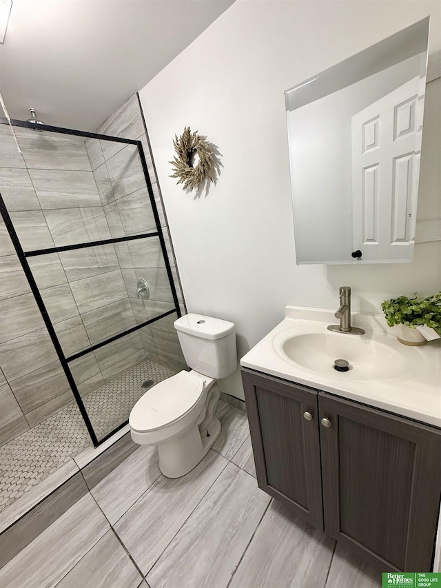 bathroom with toilet, vanity, and tiled shower