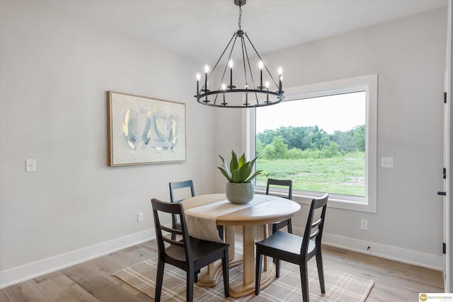 dining area featuring light wood-type flooring and a chandelier