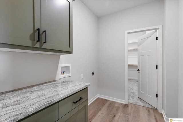 clothes washing area with cabinets, washer hookup, hookup for an electric dryer, and light hardwood / wood-style floors