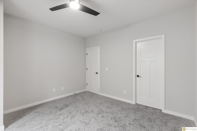 spare room featuring ceiling fan and carpet