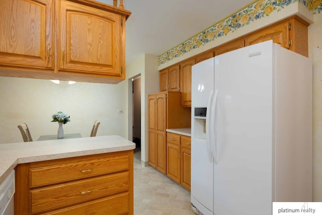 kitchen featuring white appliances and kitchen peninsula