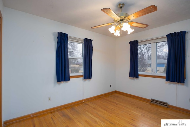 spare room featuring plenty of natural light, ceiling fan, and light hardwood / wood-style flooring