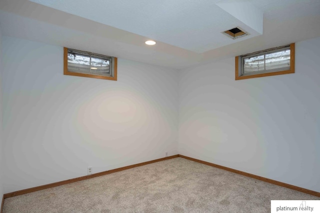 basement featuring light colored carpet and a healthy amount of sunlight