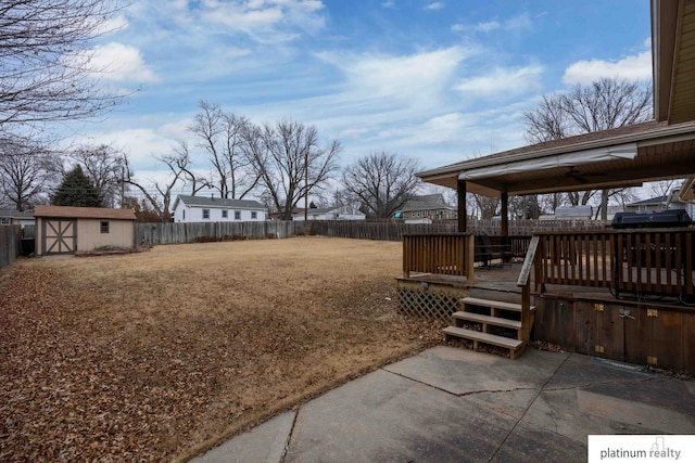 view of yard featuring a patio area, a storage unit, and a deck