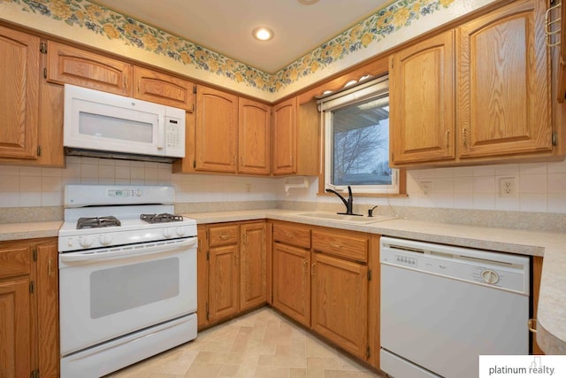 kitchen with tasteful backsplash, white appliances, and sink