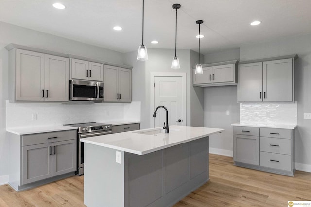 kitchen featuring gray cabinetry, stainless steel appliances, pendant lighting, and sink