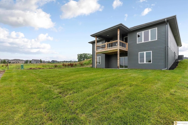 back of property with central air condition unit and a lawn