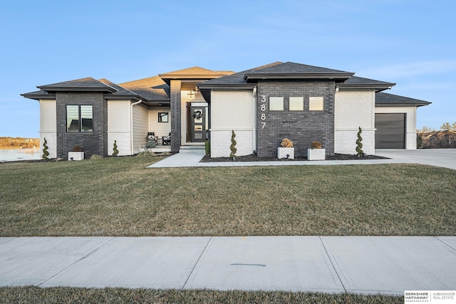 prairie-style home with a front lawn and a garage