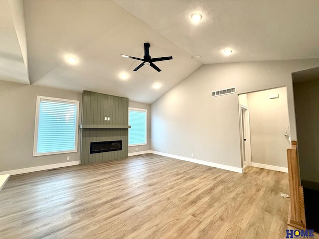 unfurnished living room featuring ceiling fan, a healthy amount of sunlight, a fireplace, and light hardwood / wood-style flooring