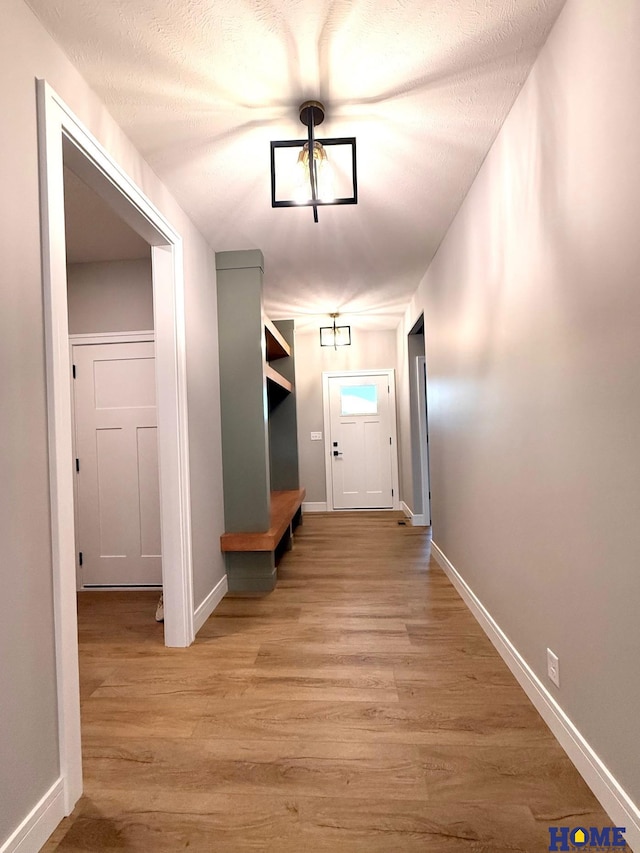 doorway to outside featuring light wood-type flooring and a textured ceiling