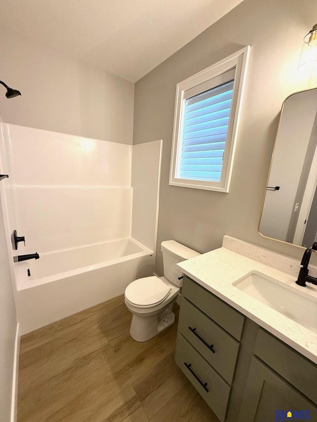 full bathroom featuring toilet, vanity, shower / bathtub combination, and hardwood / wood-style flooring