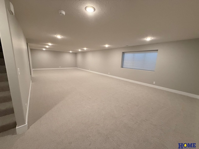 basement featuring carpet floors and a textured ceiling