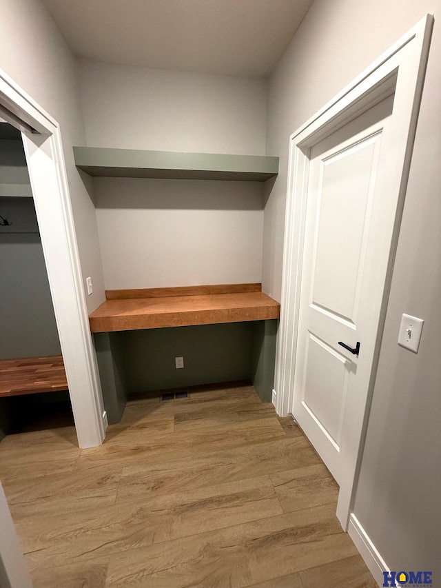 interior space featuring built in desk and light wood-type flooring