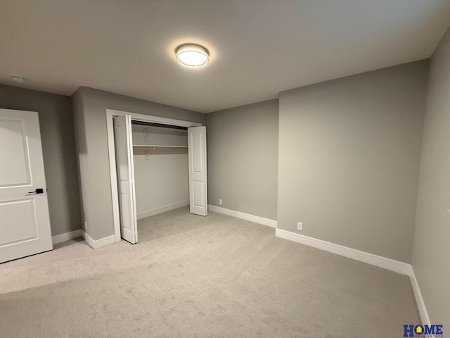 unfurnished bedroom featuring light carpet and a closet