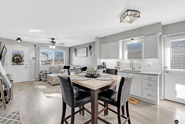 dining space with ceiling fan, sink, and light hardwood / wood-style floors