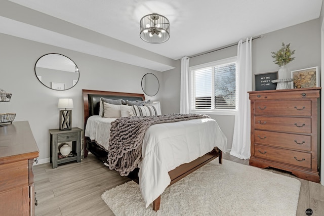 bedroom featuring light hardwood / wood-style flooring and a chandelier