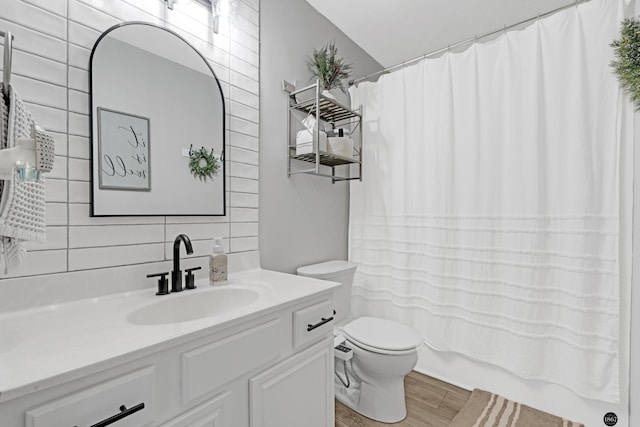 full bathroom featuring toilet, vanity, tasteful backsplash, hardwood / wood-style flooring, and shower / bath combo with shower curtain