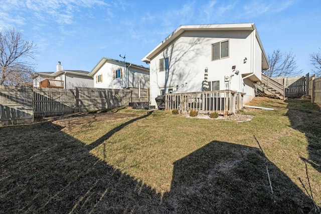 back of property with a lawn and a deck