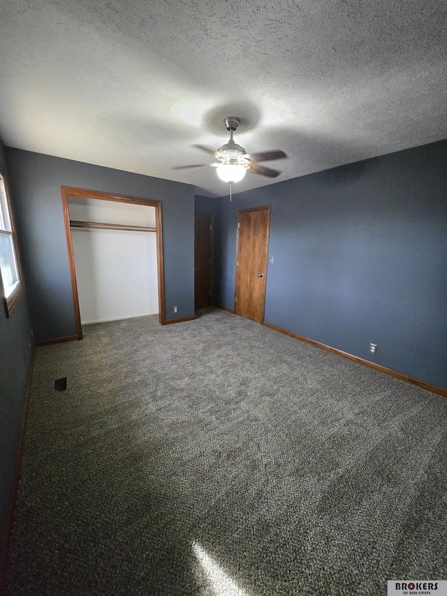 unfurnished bedroom with ceiling fan, a textured ceiling, a closet, and carpet flooring