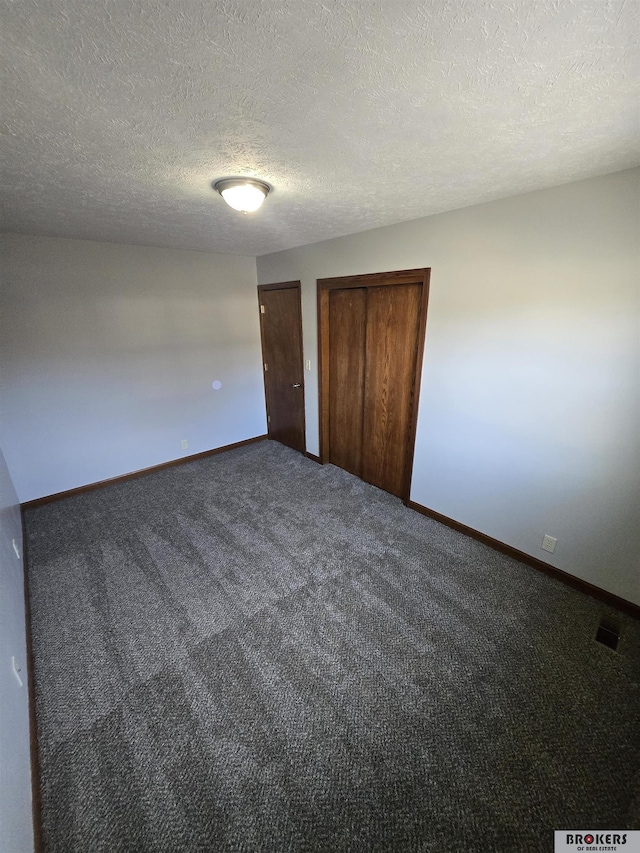 unfurnished bedroom featuring a textured ceiling and carpet