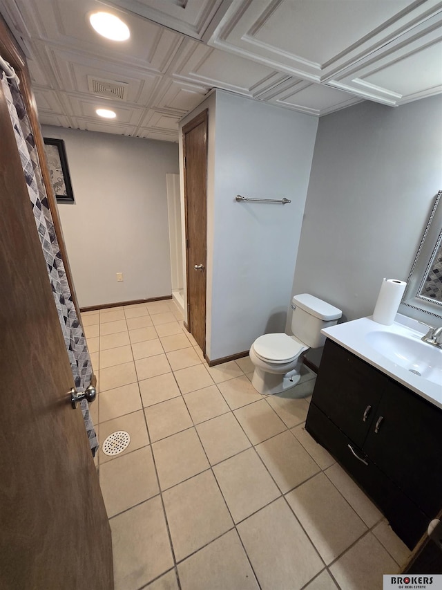 bathroom with toilet, vanity, and tile patterned floors