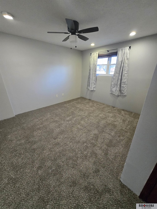 carpeted empty room with ceiling fan and a textured ceiling