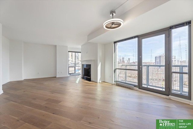 unfurnished living room with expansive windows and hardwood / wood-style flooring