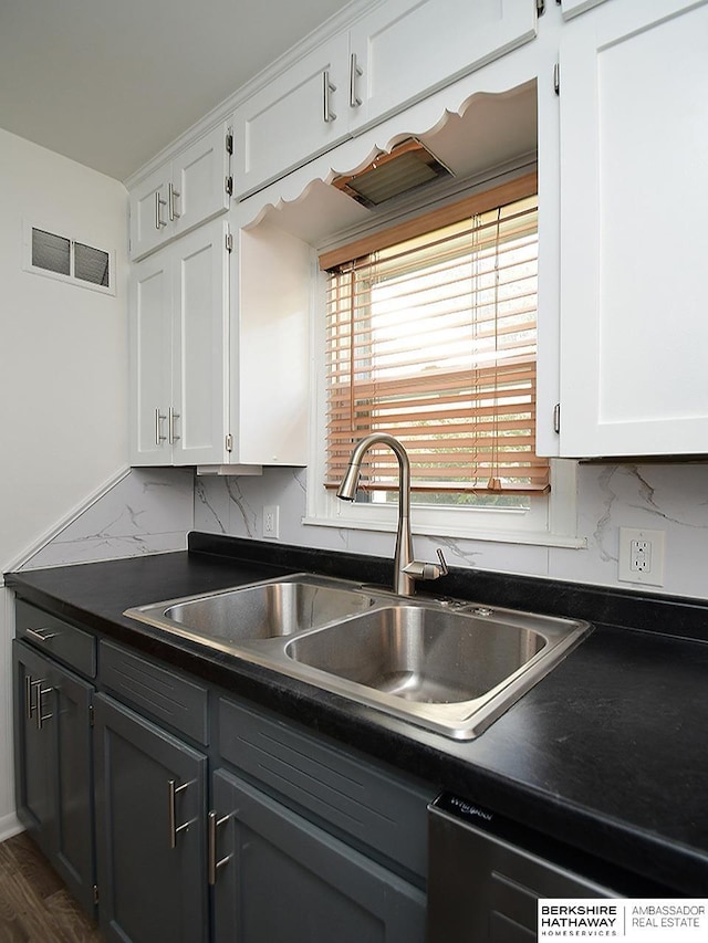 kitchen featuring dishwasher, sink, and white cabinetry