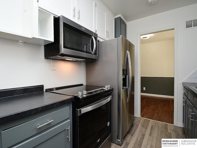 kitchen with light hardwood / wood-style floors, electric stove, white cabinets, and gray cabinetry