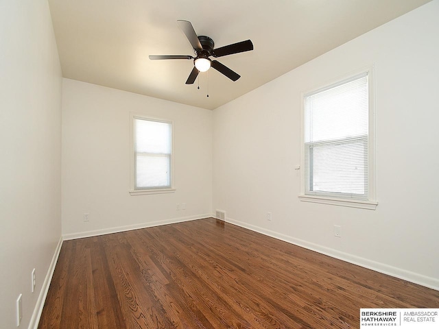 spare room featuring dark wood-type flooring and ceiling fan