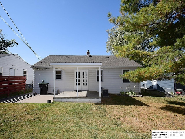 rear view of property with a lawn, central air condition unit, french doors, and a patio