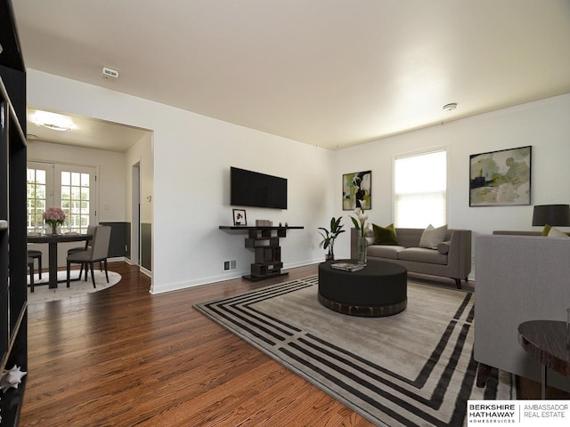 living room with dark hardwood / wood-style floors and french doors