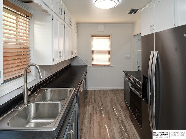 kitchen featuring white cabinets, appliances with stainless steel finishes, dark hardwood / wood-style floors, and sink