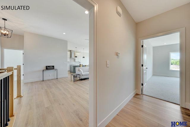 hallway featuring light hardwood / wood-style floors and a chandelier