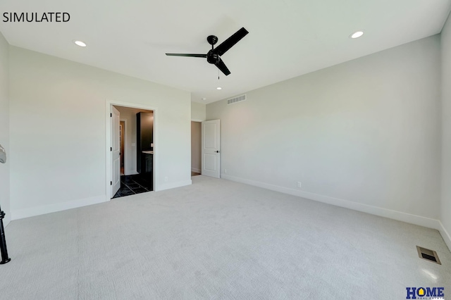 unfurnished bedroom with ceiling fan, carpet flooring, and connected bathroom