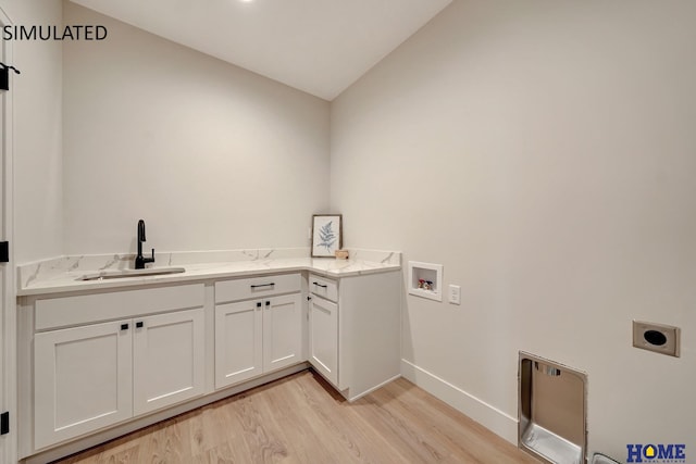 clothes washing area featuring sink, light wood-type flooring, washer hookup, hookup for an electric dryer, and cabinets