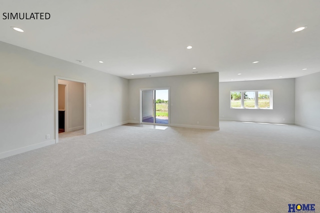 empty room featuring light colored carpet and a wealth of natural light